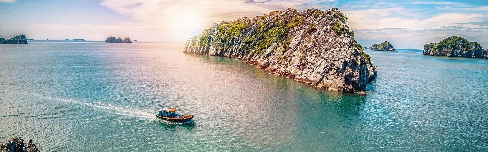 Serene Cat Ba beach sunset on a Cat Ba Travel banner by Legend Travel Group.
