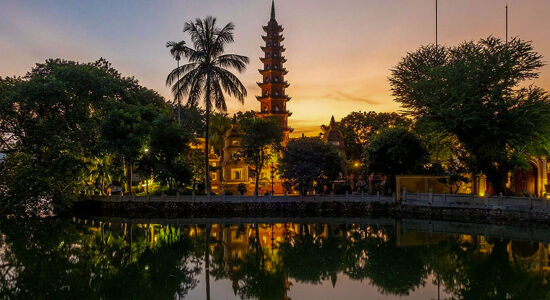 Serene Hanoi temple at sunset on a Hanoi Tours banner by Legend Travel Group.