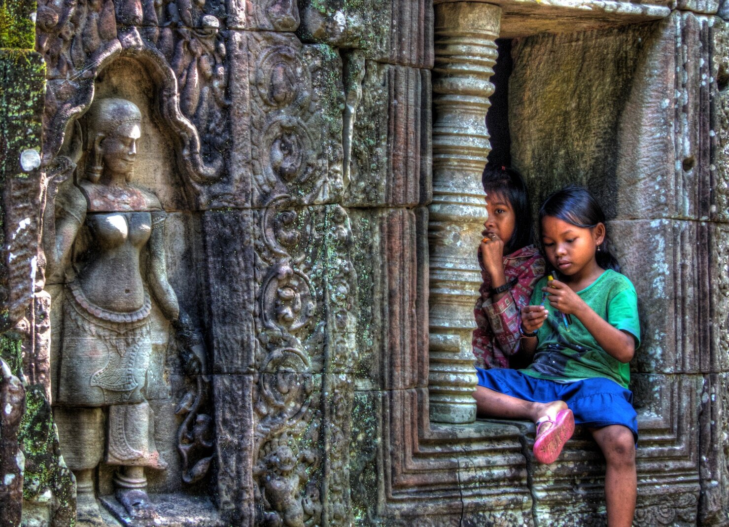 Little Khmer Girl sitting at the Temple of Angkor Complex, Siem Reap