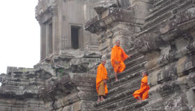 Buddhist Monks climbing on Angkor Temples, Siem Reap, Cambodia