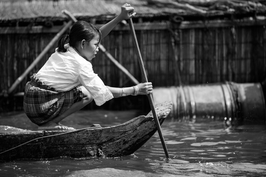 Local girl rowing Boat on Tonle Sap Lake, Cambodia
